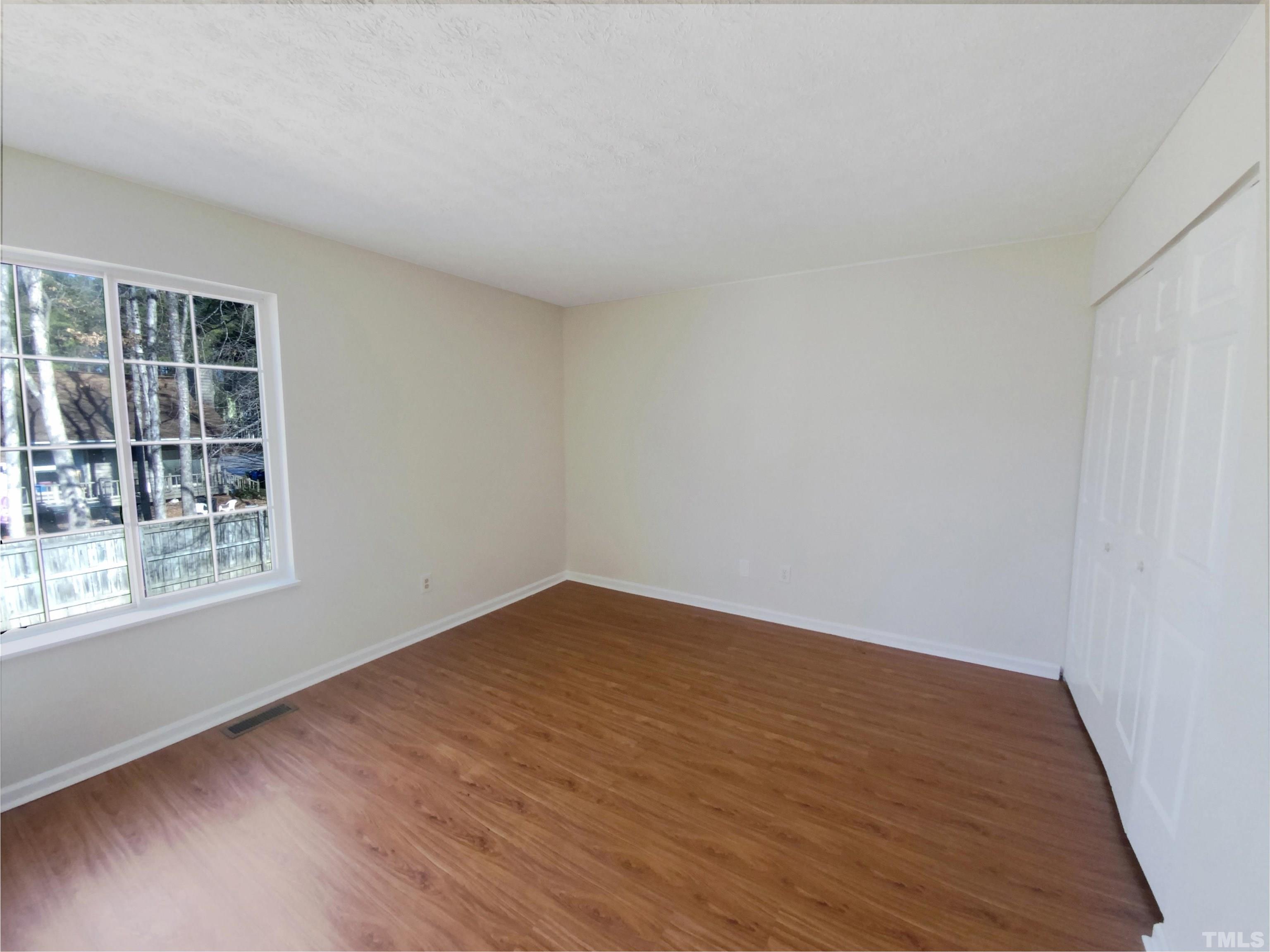 2508 Torbay Court Raleigh, NC 27613 - Photo 16 of 18 wooden floor in an empty room with a window