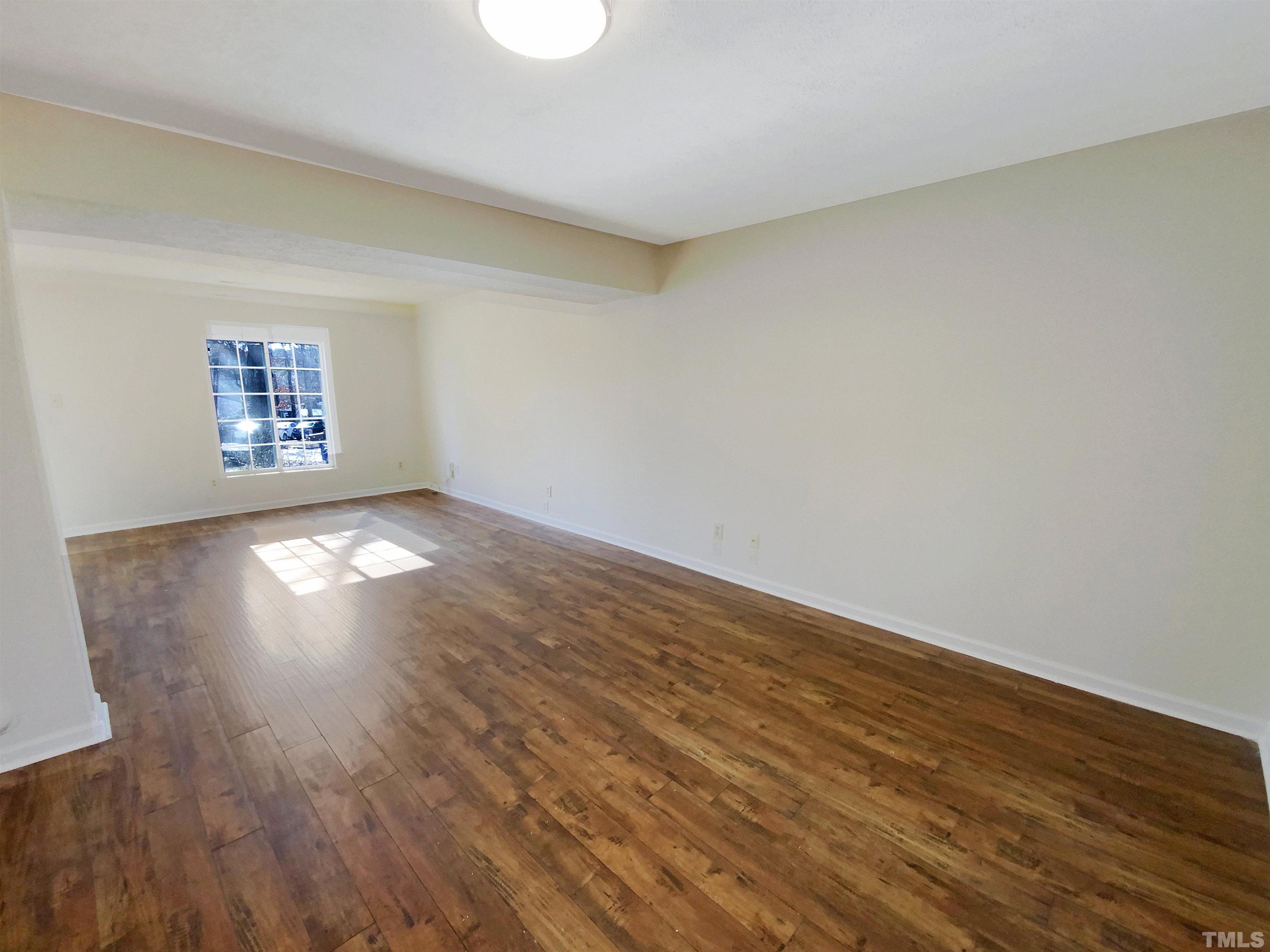 2508 Torbay Court Raleigh, NC 27613 - Photo 7 of 18 an empty room with wooden floor and windows