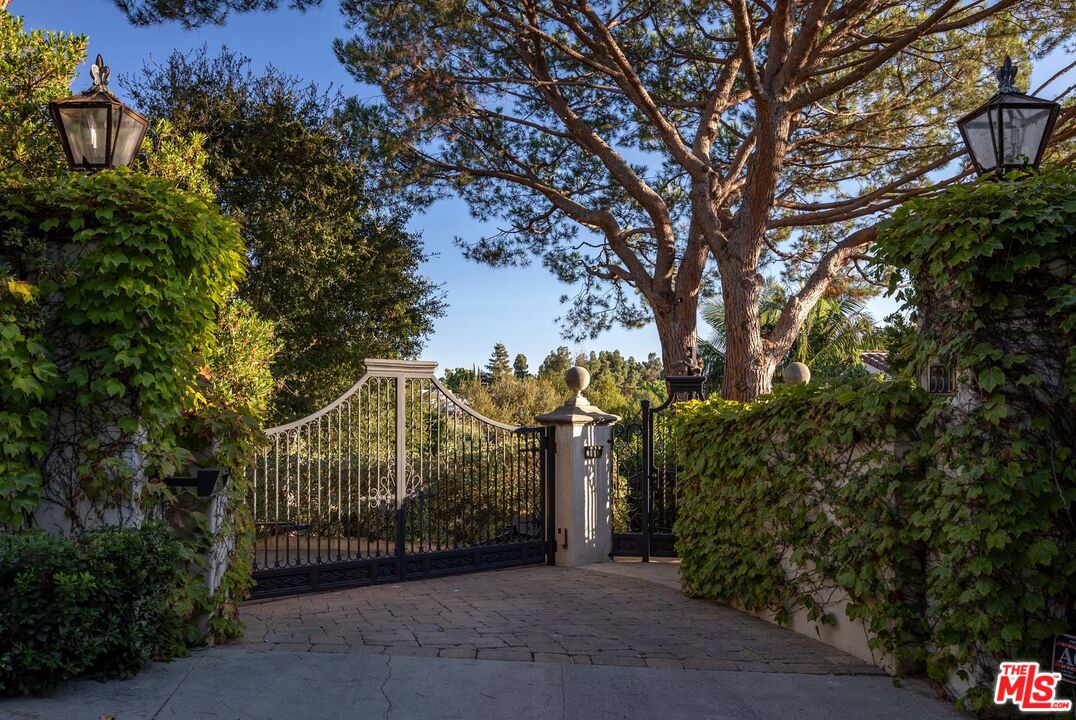 531 Barnaby Road Los Angeles, CA 90077 - Photo 22 of 28 a view of a house with a small yard and a tree