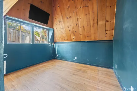 a view of a room with wooden floor and windows