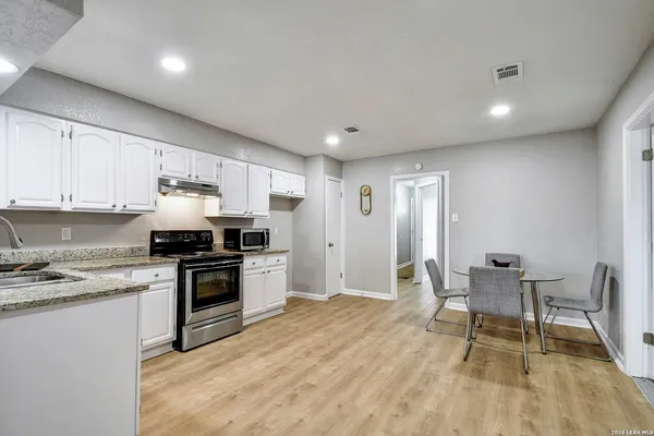 a kitchen with granite countertop a stove a sink dishwasher and a refrigerator