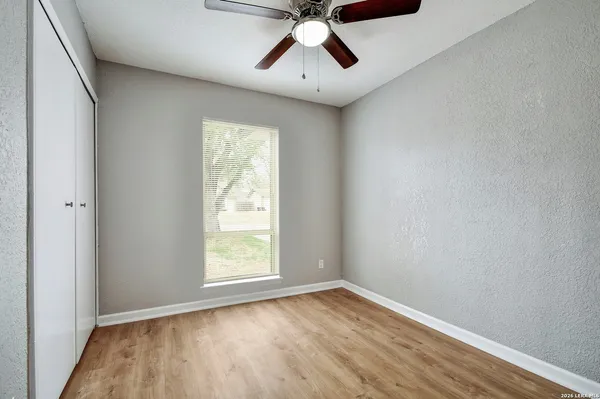 an empty room with a window and a ceiling fan