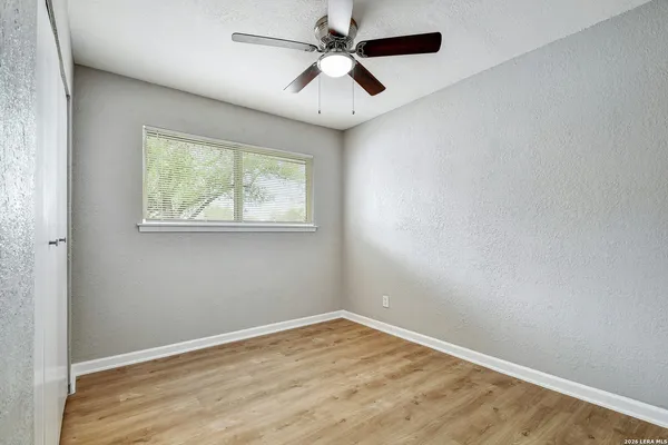 an empty room with a window and a ceiling fan