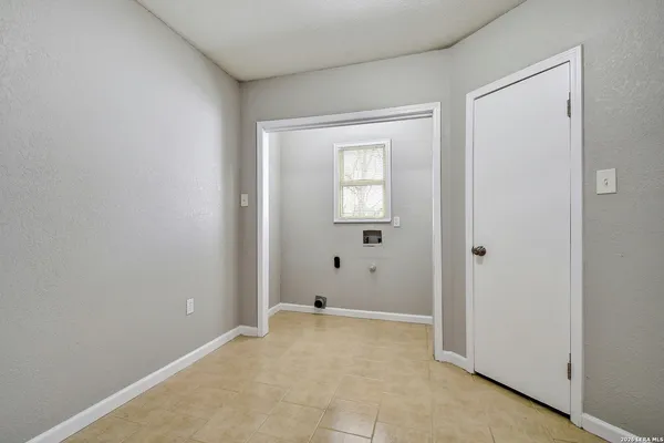a view of an empty room with closet and a mirror