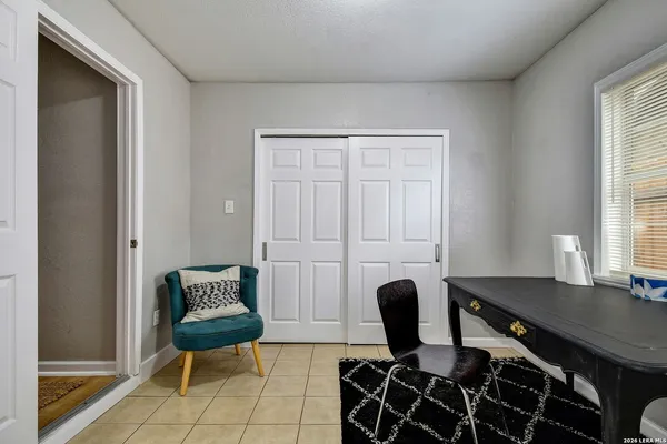 a view of a workspace with furniture and a window