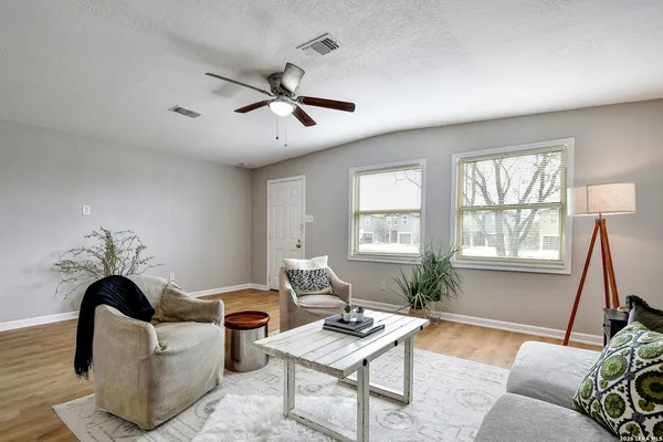 a living room with furniture a window and a potted plant