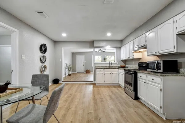 a kitchen with cabinets and wooden floor