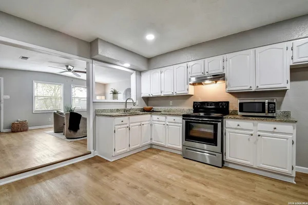 a kitchen with a stove and white cabinets