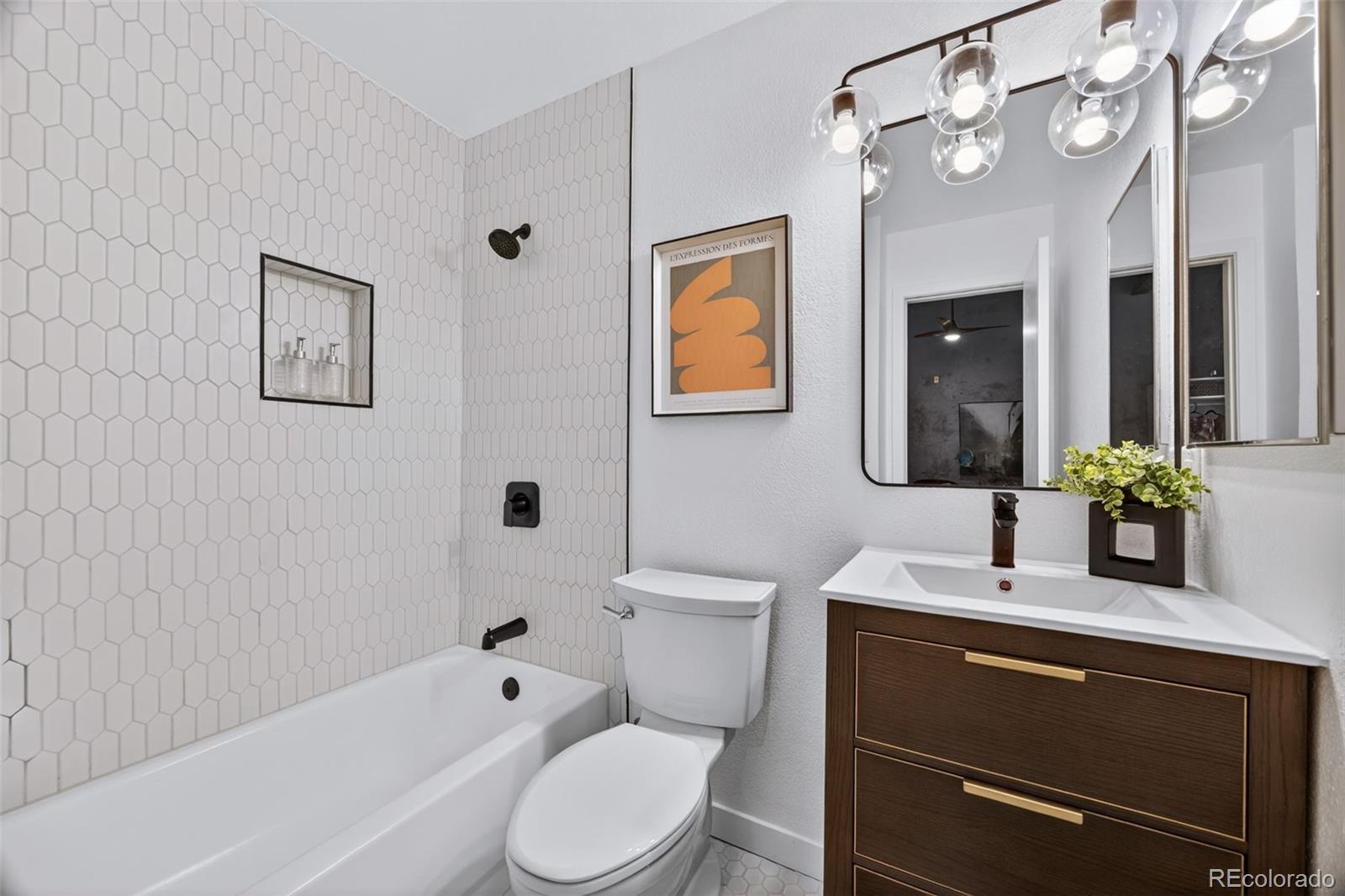 3225 Blake Street, Unit 20 Denver, CO 80205 - Photo 28 of 47 a bathroom with a toilet a sink a mirror a bathtub and shower