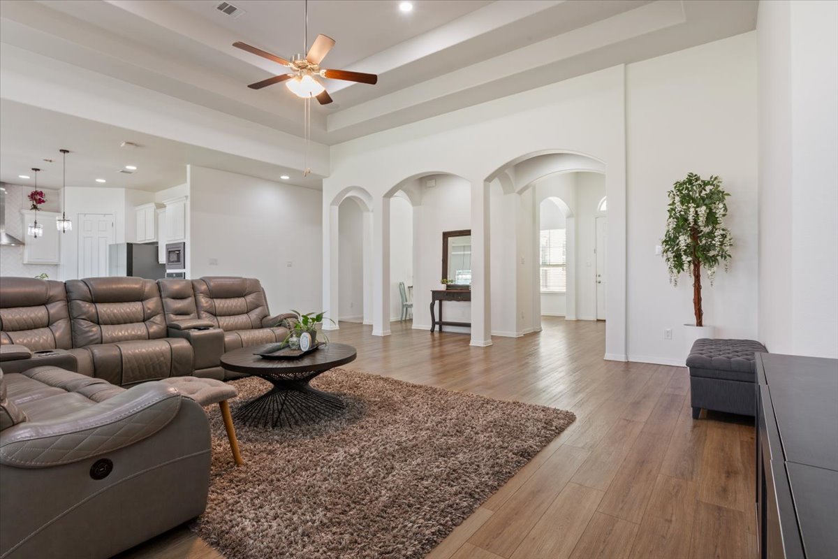 3625 Garrano Bend Leander, TX 78641 - Photo 5 of 38 Grand arched entryways and rich wood flooring create an inviting flow throughout this open concept living space.