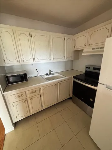 a kitchen with a sink a stove and cabinets