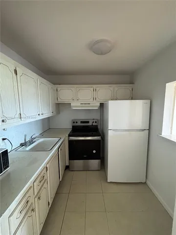 a kitchen with a refrigerator and a sink