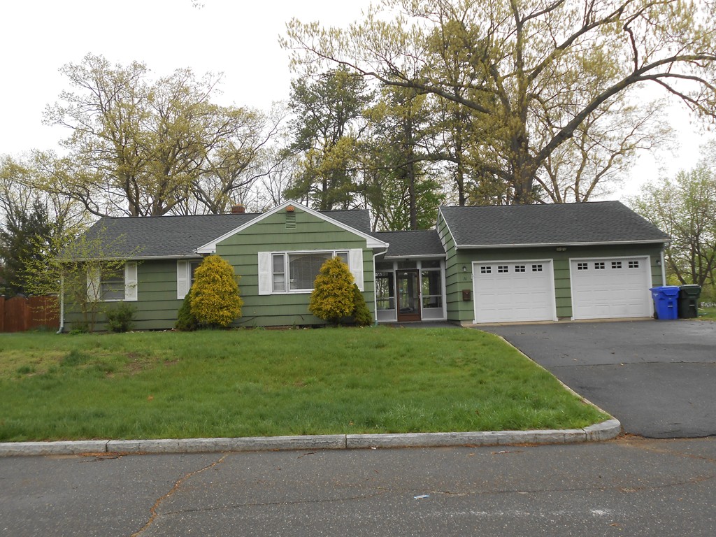 a front view of a house with a garden and trees