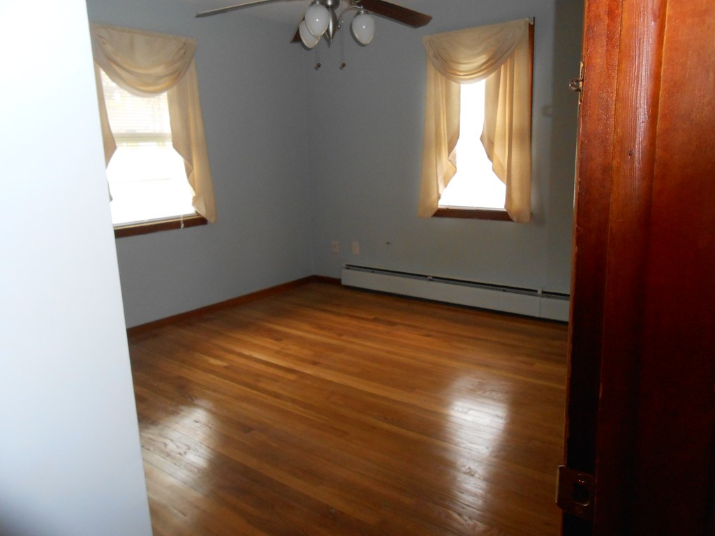 16 Varney Street Springfield, MA 01108 - Photo 2 of 6 an empty room with wooden floor and windows