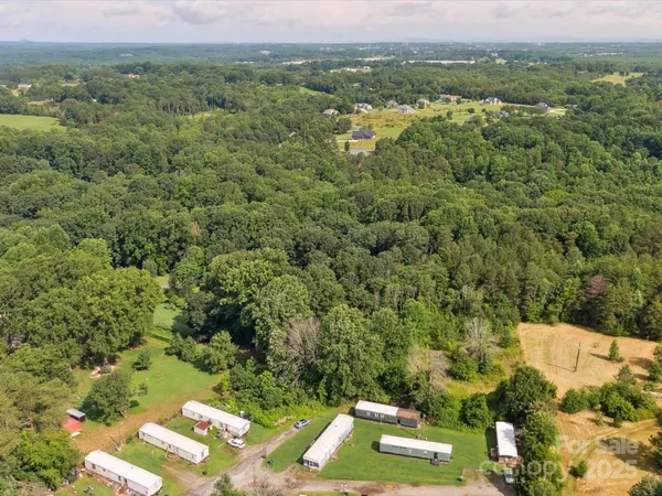 an aerial view of residential houses with outdoor space and trees