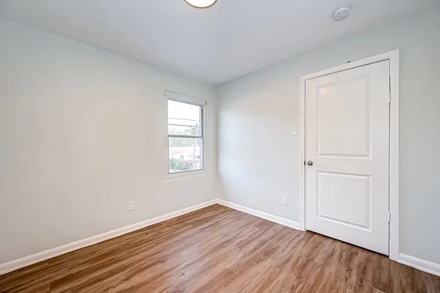a view of an empty room with wooden floor
