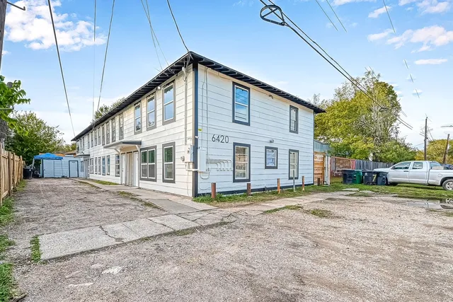 a view of a house with a big yard and large trees