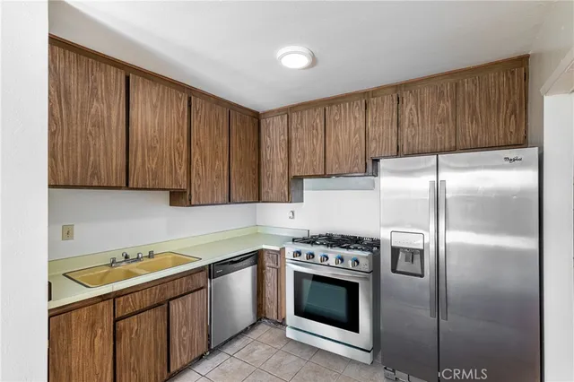 a kitchen with a refrigerator sink and cabinets