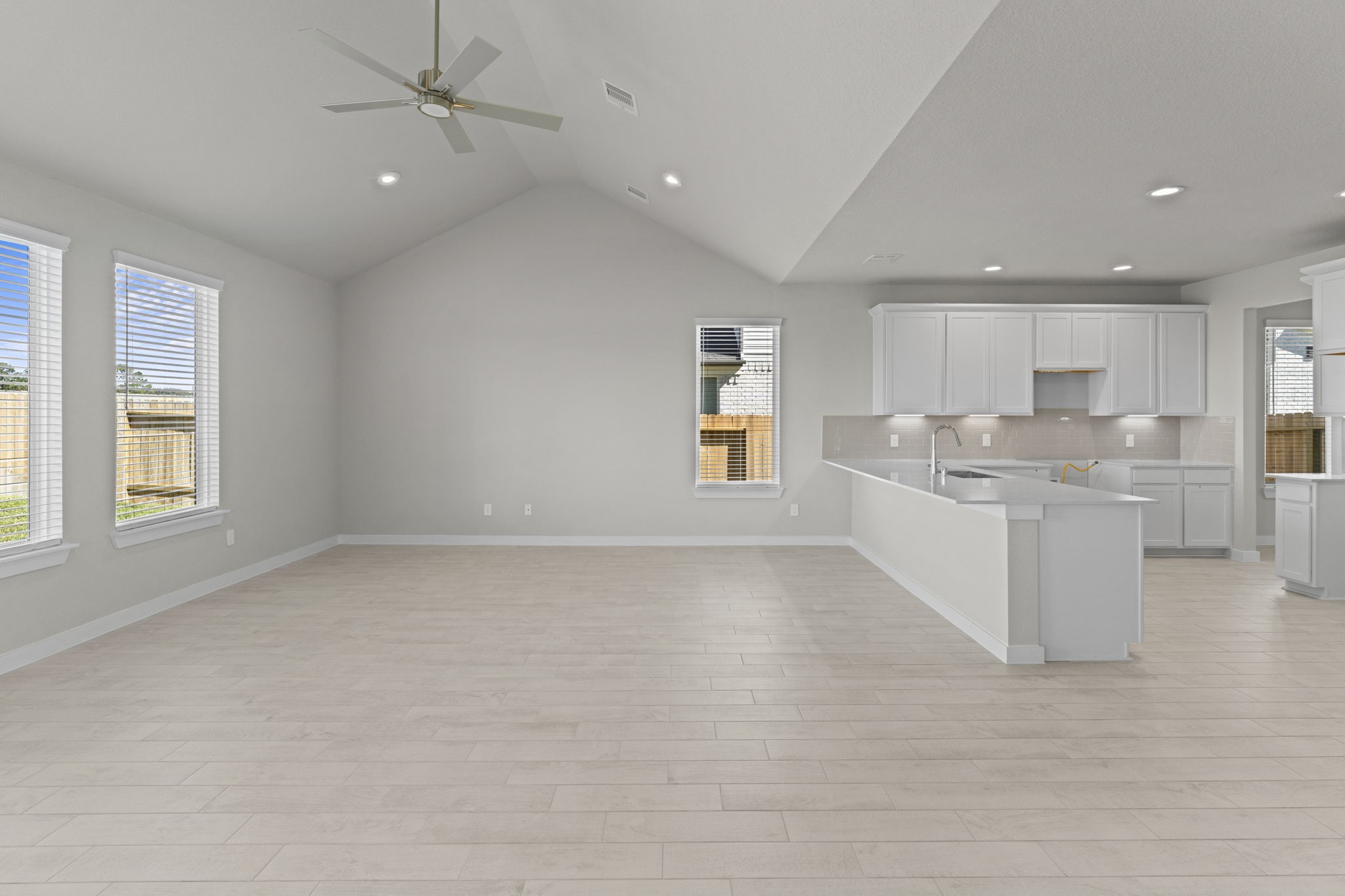 3102 Boulder Ridge Drive Rosenberg, TX 77471 - Photo 8 of 47 a large white kitchen with kitchen island a sink dishwasher a stove and a refrigerator with wooden floor