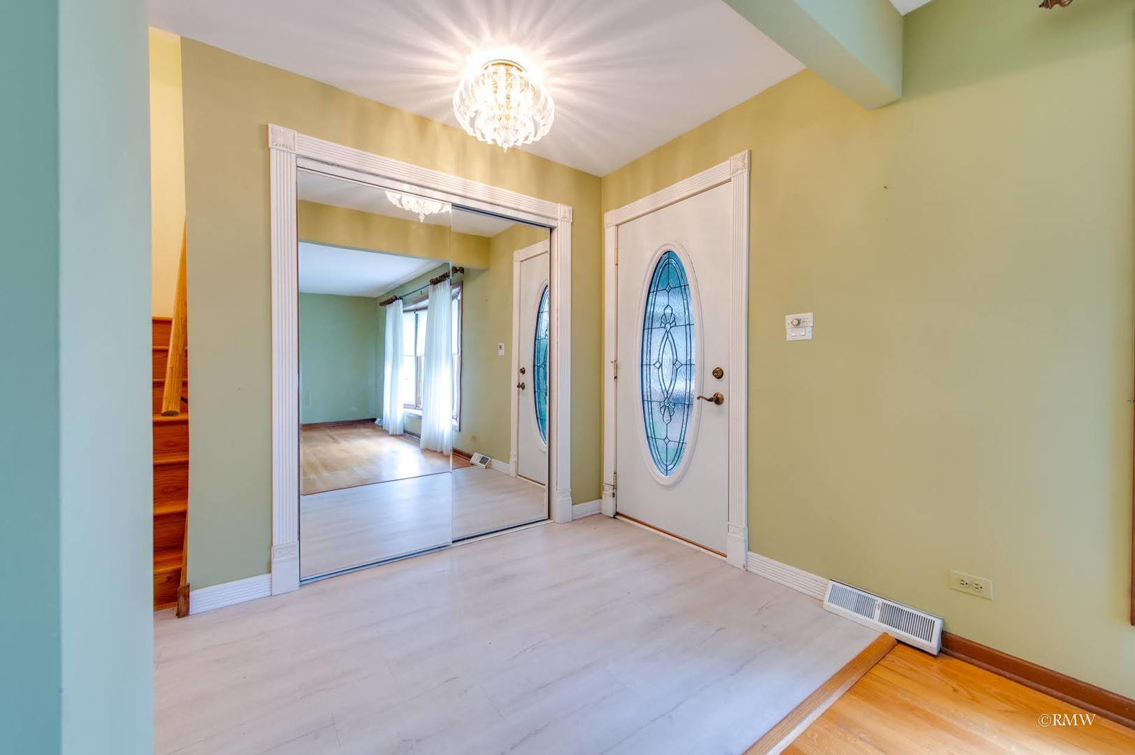 1906 McAdam Road Darien, IL 60561 - Photo 18 of 32 an empty room with a mirror and a chandelier fan