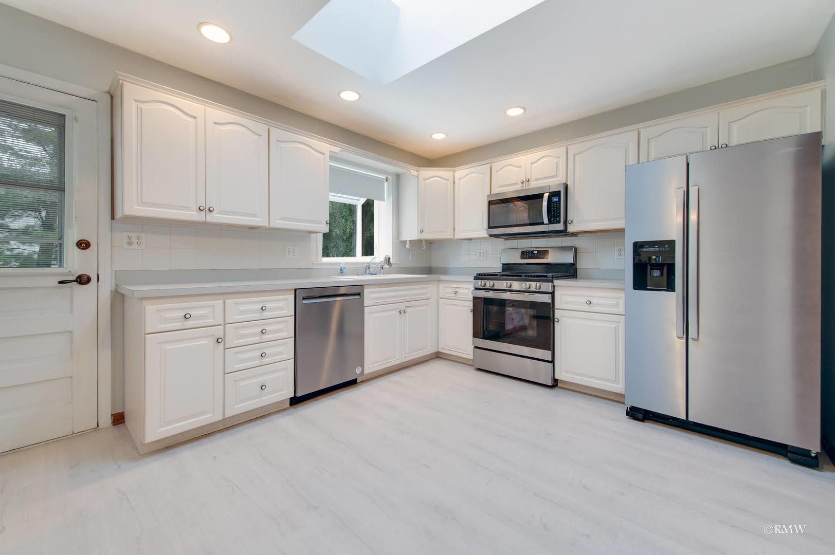 1906 McAdam Road Darien, IL 60561 - Photo 7 of 32 a kitchen with white cabinets and stainless steel appliances