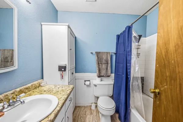 a bathroom with a granite countertop toilet sink and mirror