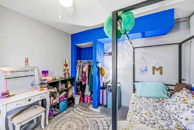 a bedroom with a bed a dresser and book shelf