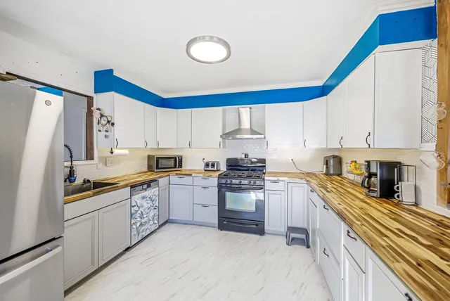 a kitchen with stainless steel appliances granite countertop a stove a sink and a refrigerator