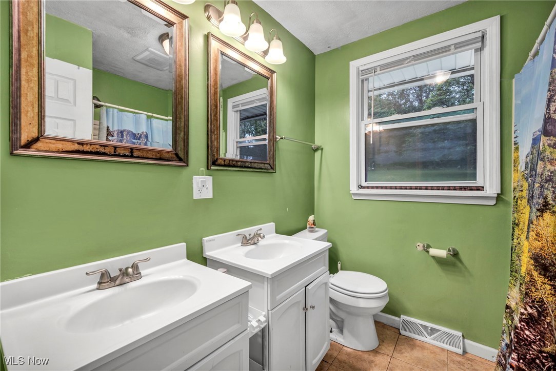 3954 Homestead Road Ravenna, OH 44266 - Photo 33 of 46 Bathroom with two vanities, tile patterned flooring, and a shower with shower curtain