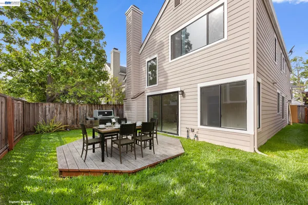 a view of a patio with table and chairs potted plants and large tree