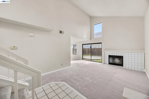 a view of an empty room with a fireplace and a window