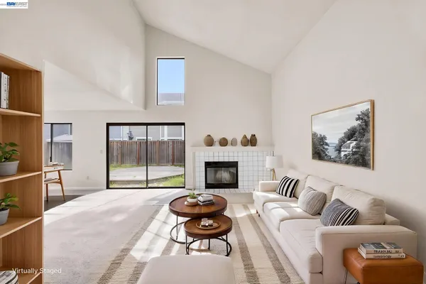 a living room with furniture a fireplace and a floor to ceiling window