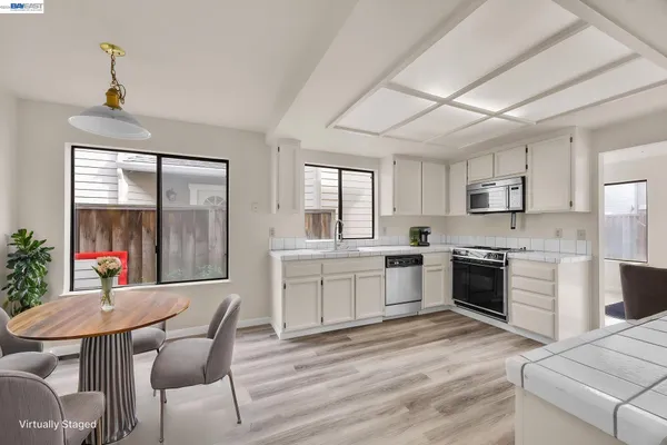 a kitchen with a table chairs microwave and cabinets