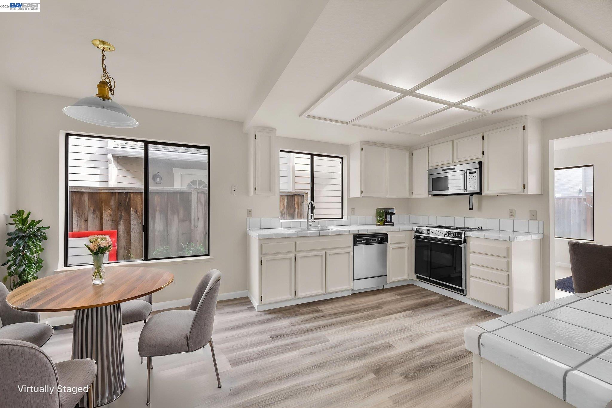 1068 Foster Street Alameda, CA 94502 - Photo 5 of 17 a kitchen with a table chairs microwave and cabinets