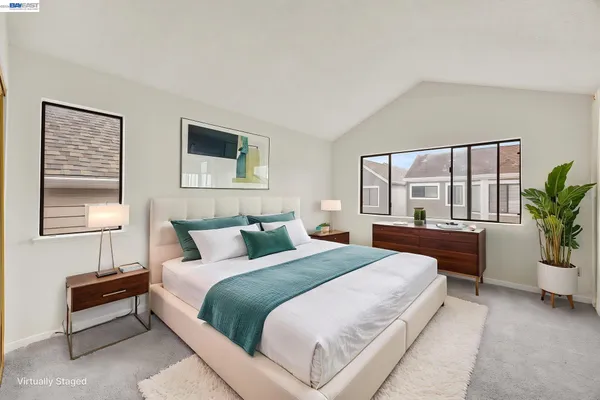 a bedroom with a large bed and a potted plant