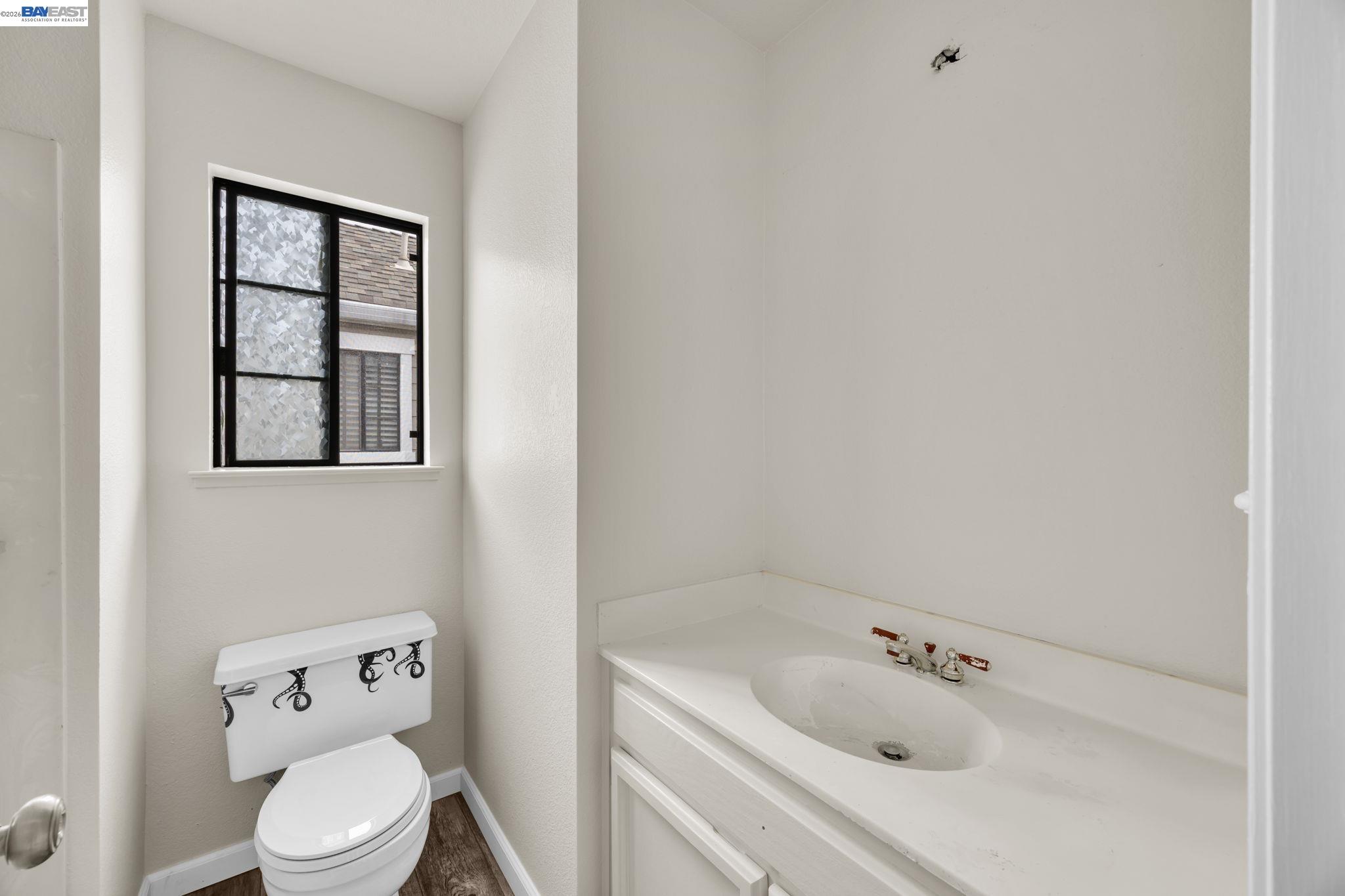 1068 Foster Street Alameda, CA 94502 - Photo 10 of 17 a white toilet sitting next to a bathroom sink