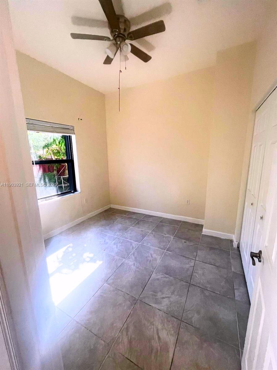 116 Northeast 25th Terrace Homestead, FL 33033 - Photo 9 of 9 en empty room with windows and ceiling fan