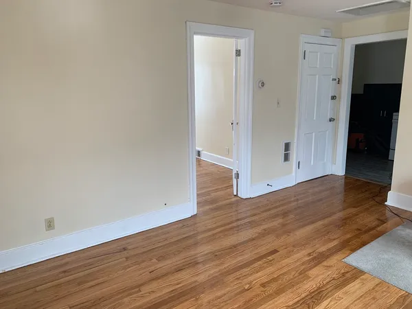 a view of an empty room with wooden floor
