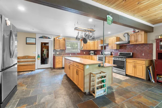 a kitchen with stainless steel appliances granite countertop a stove and a refrigerator