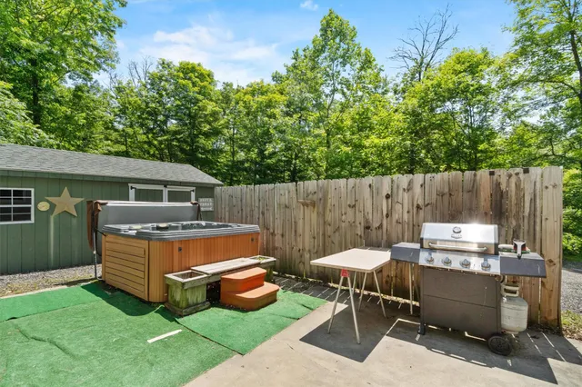 a view of a patio with a table chairs and a barbeque