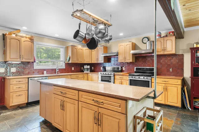 a kitchen with stainless steel appliances granite countertop a stove and cabinets