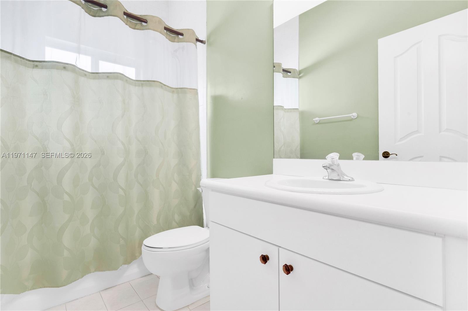 2875 Northeast 4th Street Homestead, FL 33033 - Photo 26 of 53 a bathroom with a sink a toilet and shower curtain