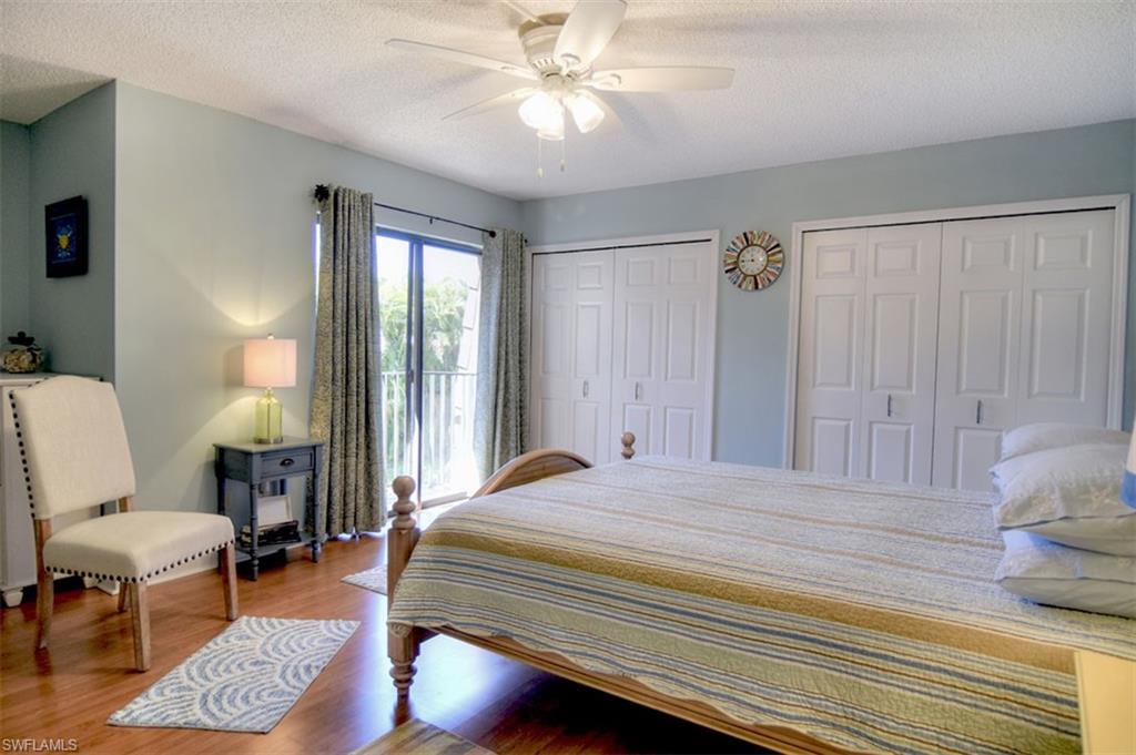 1468 Park Shore Circle, Unit 4 Fort Myers, FL 33901 - Photo 17 of 32 a bedroom with a bed a chair and a chandelier
