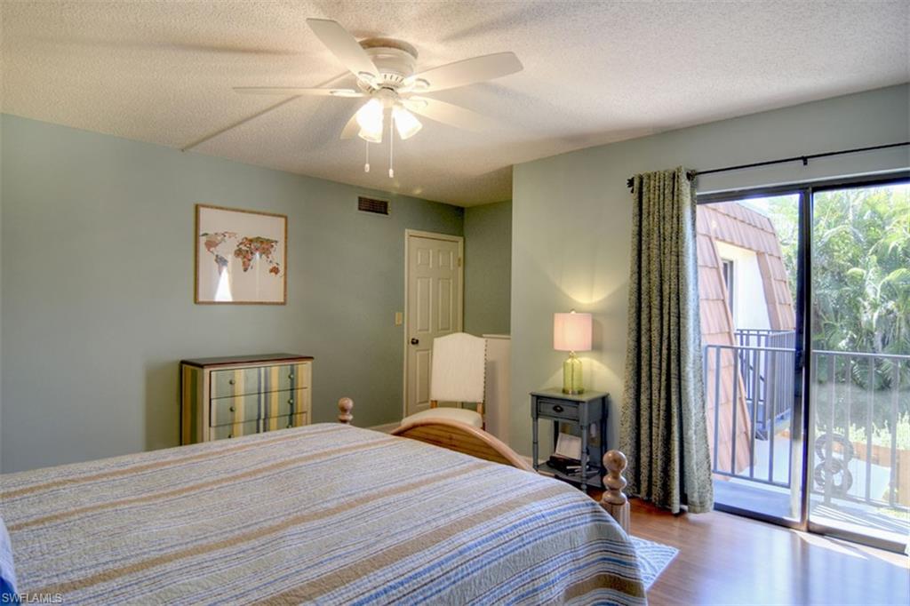 1468 Park Shore Circle, Unit 4 Fort Myers, FL 33901 - Photo 18 of 32 a bedroom with a bed and a chandelier