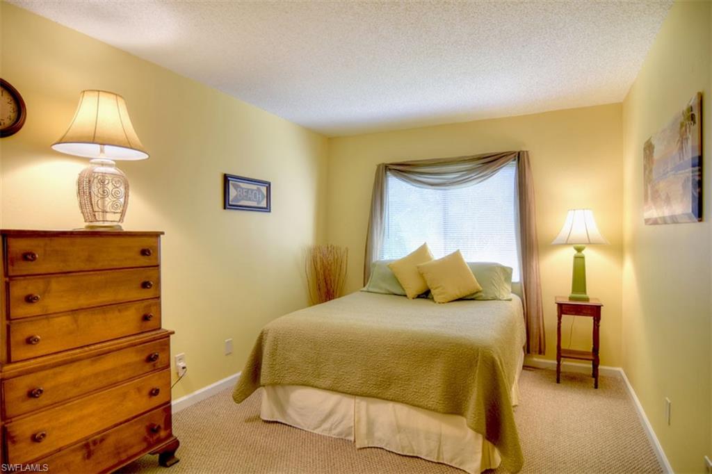 1468 Park Shore Circle, Unit 4 Fort Myers, FL 33901 - Photo 23 of 32 a bedroom with a bed and a lamp