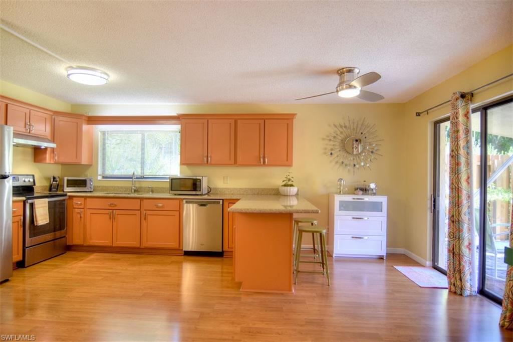 1468 Park Shore Circle, Unit 4 Fort Myers, FL 33901 - Photo 7 of 32 a kitchen with granite countertop a stove top oven sink and cabinets
