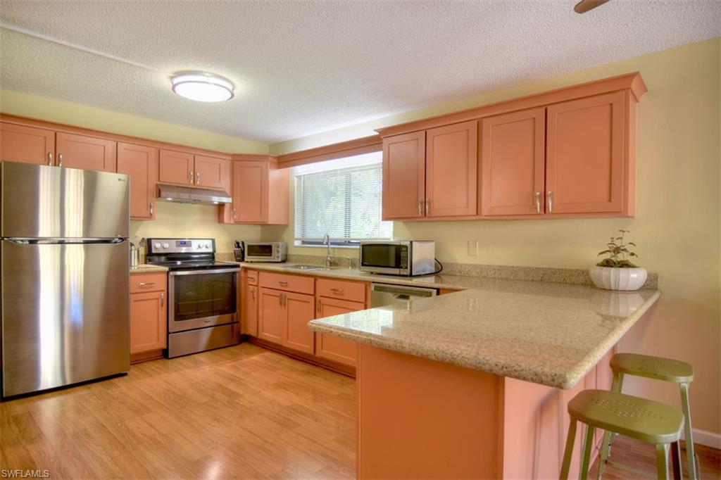 1468 Park Shore Circle, Unit 4 Fort Myers, FL 33901 - Photo 8 of 32 a kitchen with stainless steel appliances granite countertop a refrigerator sink and cabinets