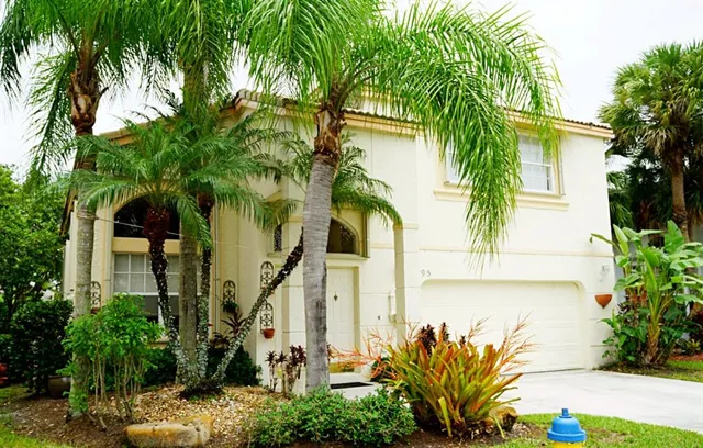 a front view of a house with a tree
