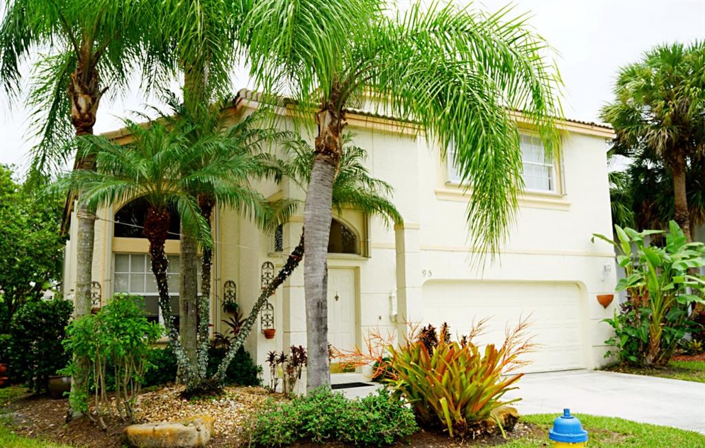 a front view of a house with a tree