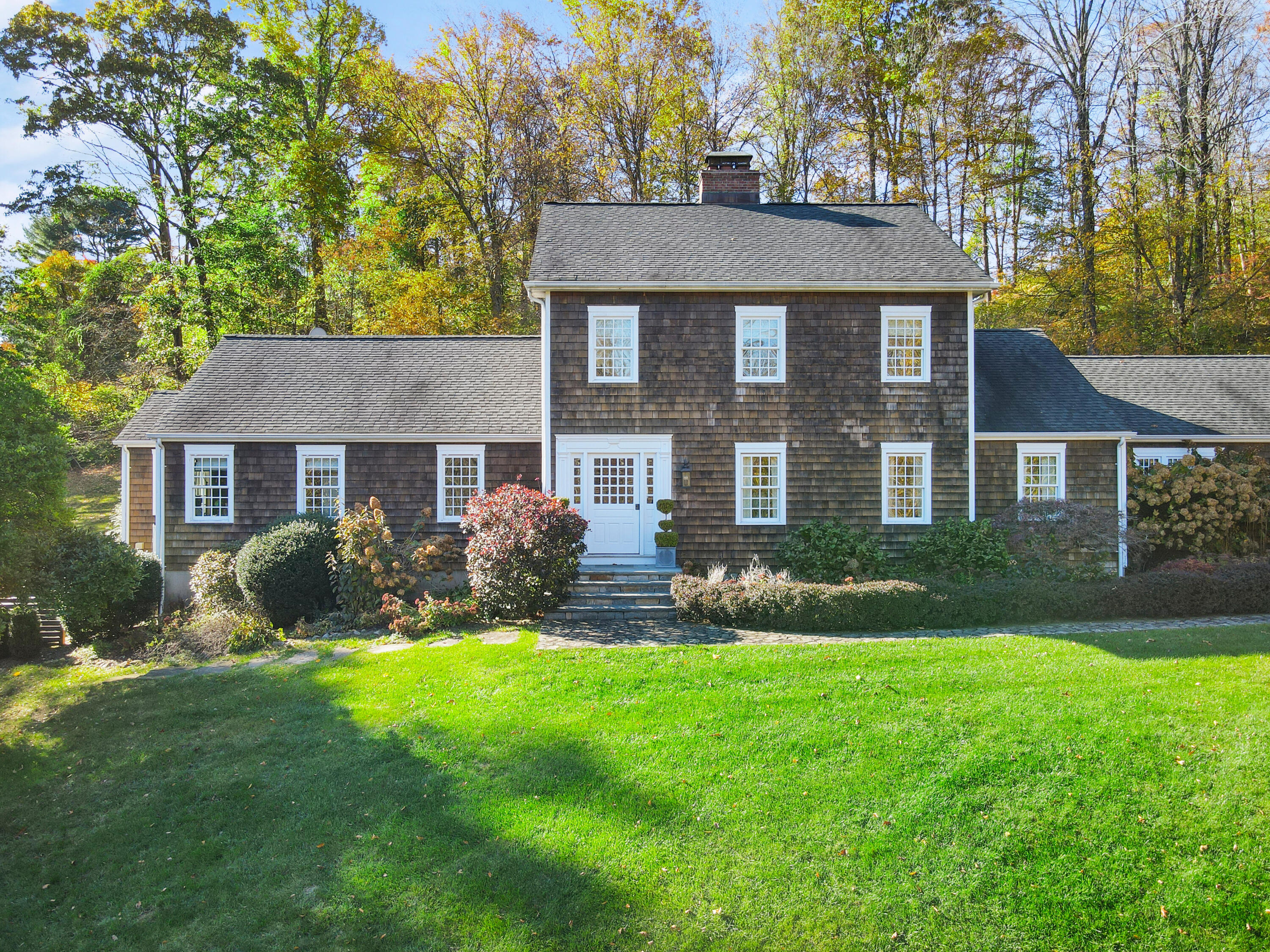 215 Cross Ridge Road New Canaan, CT 06840 - Photo 2 of 50 a front view of a house with a yard and green space